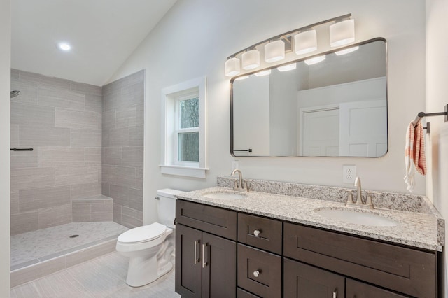 bathroom featuring vaulted ceiling, toilet, a shower, tile patterned floors, and vanity