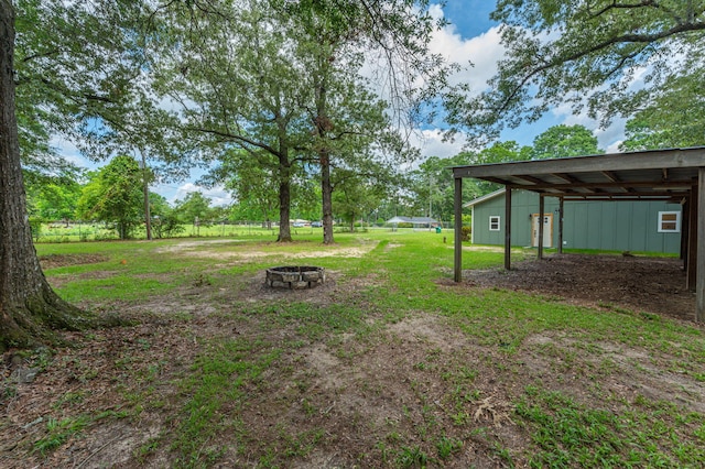 view of yard with a fire pit and an outdoor structure