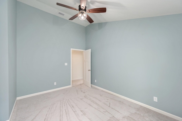 spare room featuring ceiling fan, light carpet, and lofted ceiling