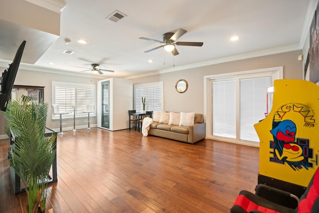 living room featuring ornamental molding, wood-type flooring, and ceiling fan