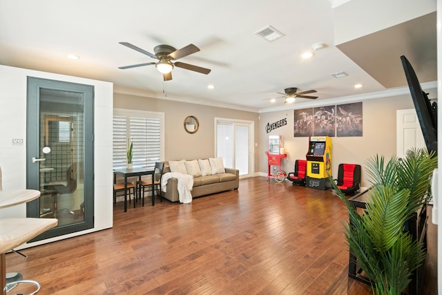 living room with ceiling fan, ornamental molding, and wood-type flooring