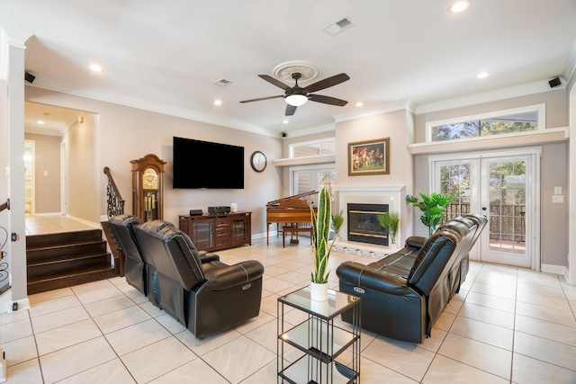 tiled living room featuring ornamental molding, ceiling fan, and french doors