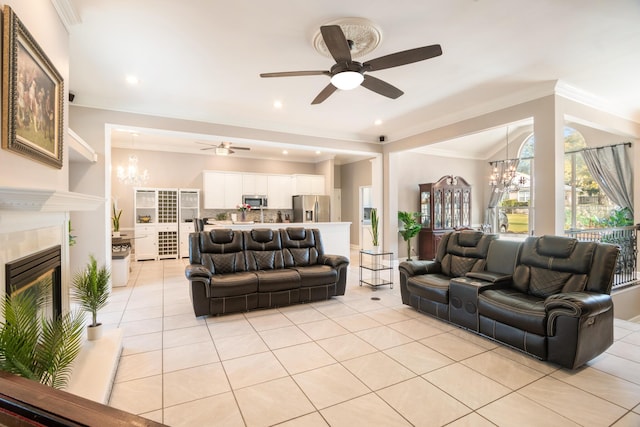 living room with light tile patterned flooring, ceiling fan with notable chandelier, and crown molding