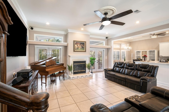 living room with french doors, crown molding, ceiling fan with notable chandelier, and light tile patterned floors