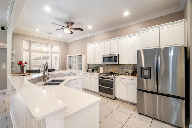 kitchen featuring sink, appliances with stainless steel finishes, white cabinetry, hanging light fixtures, and ornamental molding