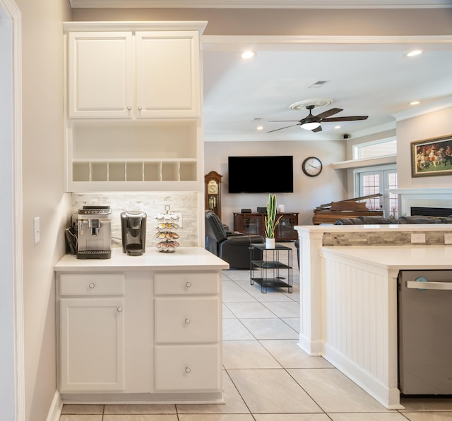 kitchen featuring ceiling fan, light tile patterned floors, stainless steel dishwasher, and white cabinets