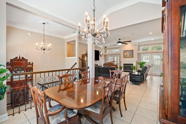 tiled dining area featuring lofted ceiling, ceiling fan with notable chandelier, and ornamental molding