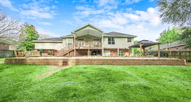 back of house with a gazebo, a wooden deck, and a lawn