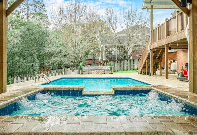 view of pool with a wooden deck, a jacuzzi, and pool water feature