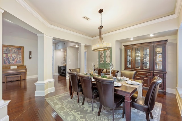 dining area with ornate columns, dark hardwood / wood-style flooring, and crown molding