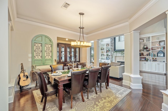 dining space with ornate columns, ornamental molding, built in features, and dark hardwood / wood-style floors