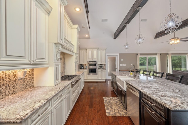 kitchen with stainless steel appliances, a large island, beam ceiling, a breakfast bar area, and sink