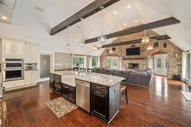 kitchen with stainless steel appliances, high vaulted ceiling, a kitchen bar, and beam ceiling