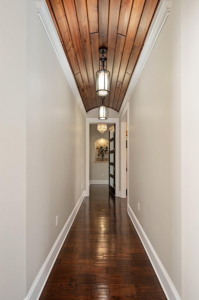 hallway featuring an inviting chandelier, crown molding, wooden ceiling, and dark hardwood / wood-style floors