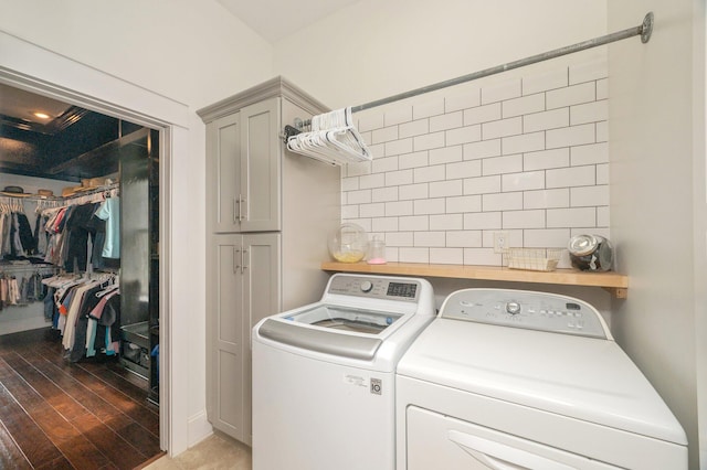 clothes washing area featuring light hardwood / wood-style flooring, cabinets, and washer and clothes dryer