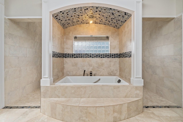 bathroom with independent shower and bath, tile patterned flooring, tile walls, and lofted ceiling