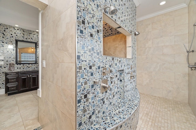 bathroom with tile walls, a tile shower, crown molding, and vanity