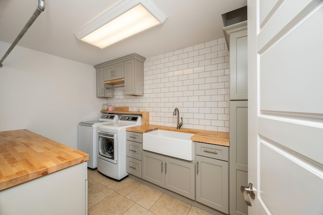 laundry area featuring sink, cabinets, independent washer and dryer, and light tile patterned floors