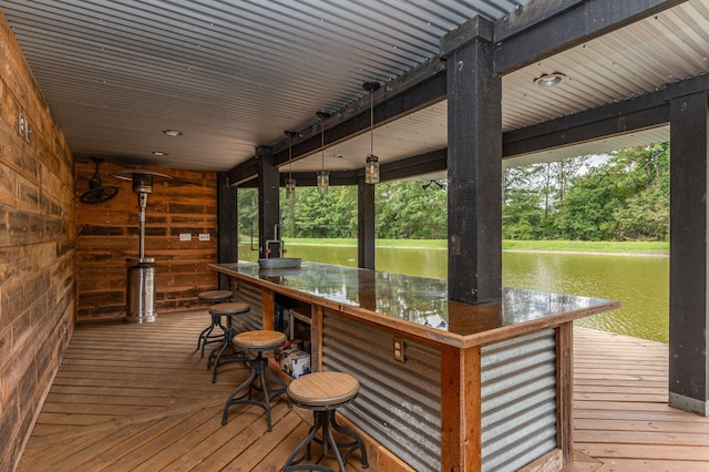 deck with an outdoor bar and a water view