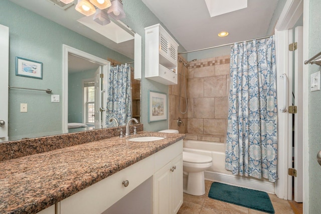 full bathroom featuring toilet, a skylight, tile patterned floors, vanity, and shower / bath combo