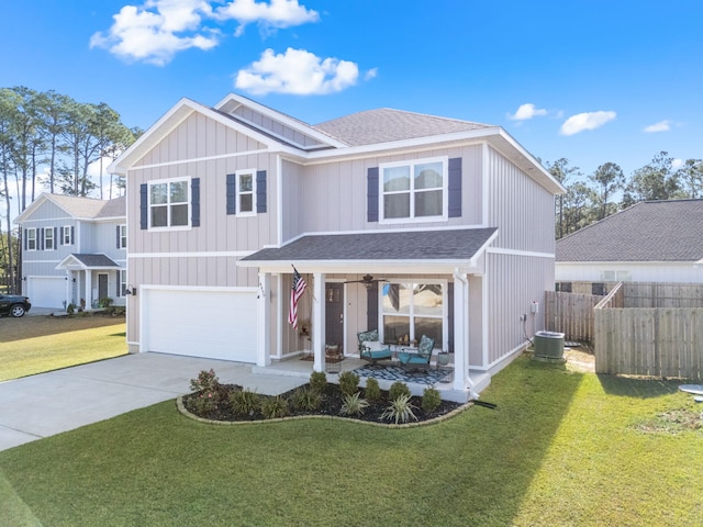 traditional home featuring a garage, driveway, a shingled roof, fence, and a front lawn