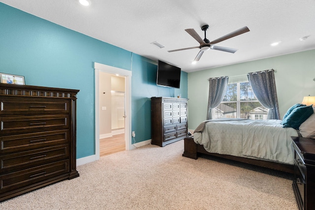 carpeted bedroom featuring a textured ceiling, ceiling fan, and ensuite bathroom