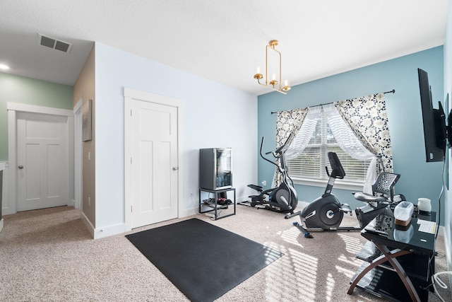 workout area featuring an inviting chandelier and carpet floors