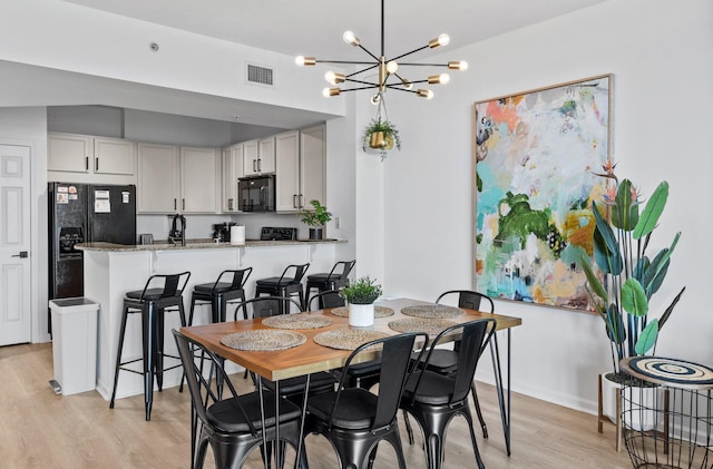 dining room with a chandelier and light hardwood / wood-style flooring