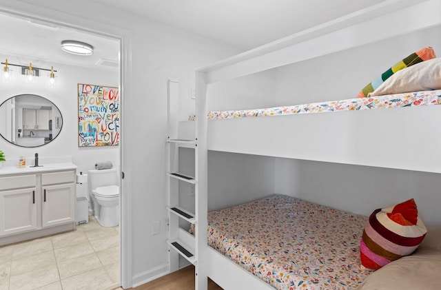 bedroom with ensuite bath and light tile patterned floors