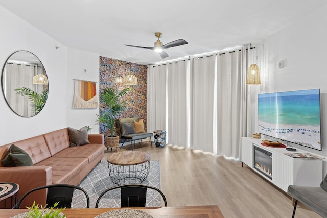 living room featuring ceiling fan and light hardwood / wood-style floors