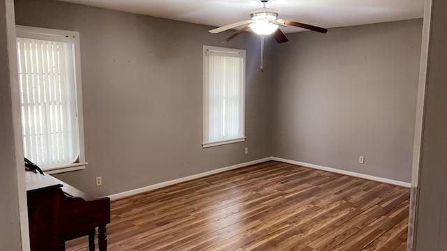 spare room featuring dark hardwood / wood-style floors, ceiling fan, and plenty of natural light