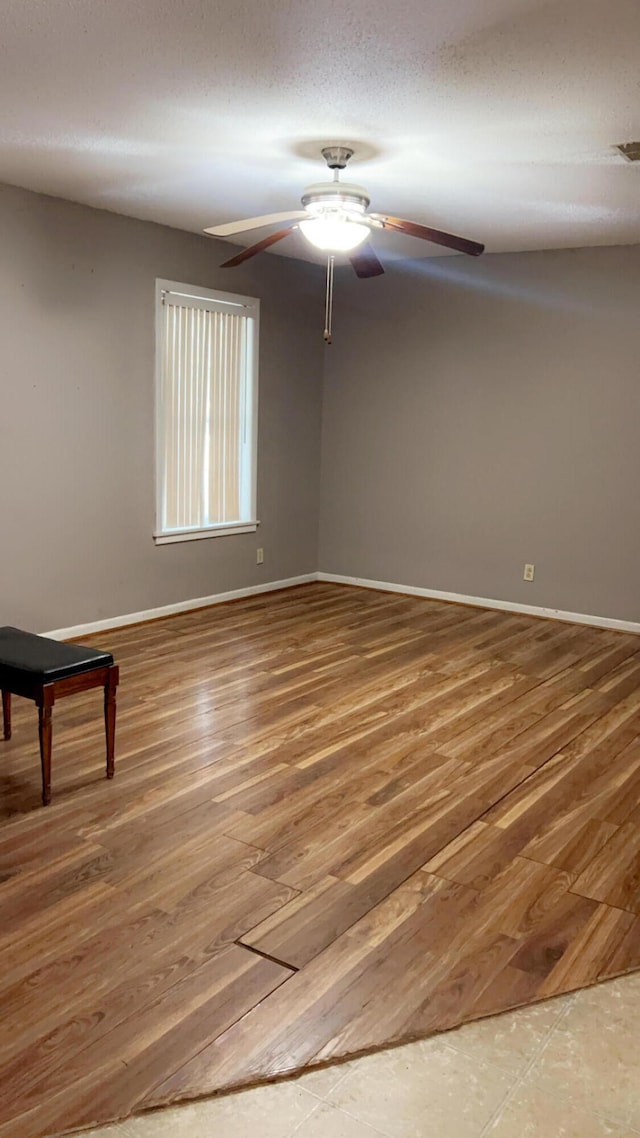 spare room with a textured ceiling, ceiling fan, pool table, and hardwood / wood-style floors