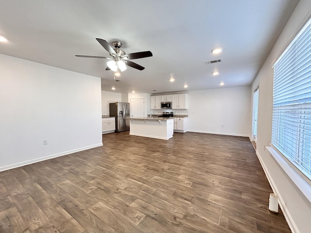 unfurnished living room with ceiling fan and dark hardwood / wood-style flooring