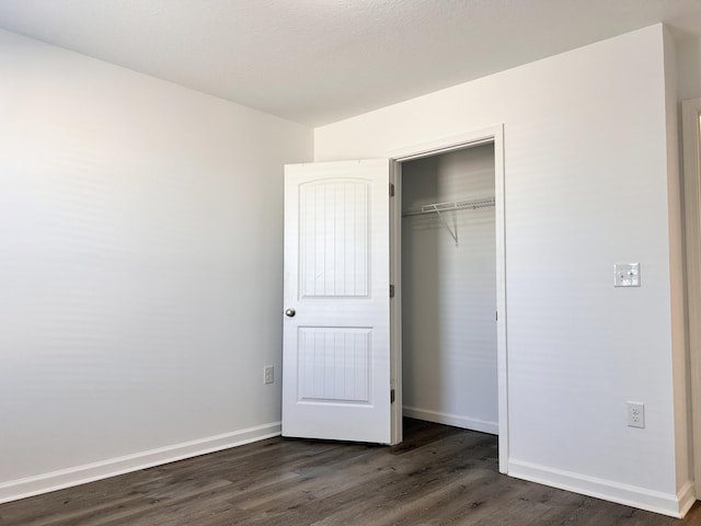 unfurnished bedroom featuring dark hardwood / wood-style floors and a closet