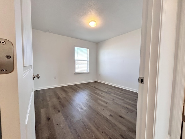 unfurnished room with dark wood-type flooring and a textured ceiling