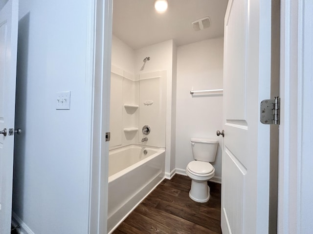 bathroom featuring hardwood / wood-style flooring, shower / tub combination, and toilet