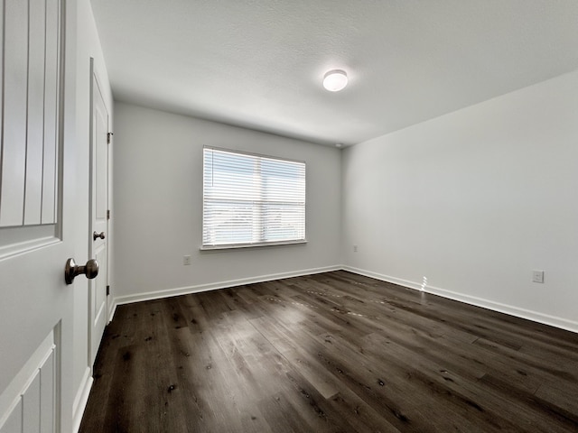 empty room with dark hardwood / wood-style flooring