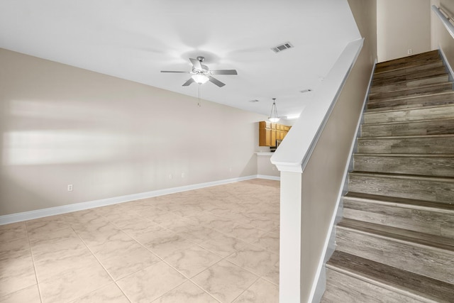 stairway with tile patterned floors and ceiling fan