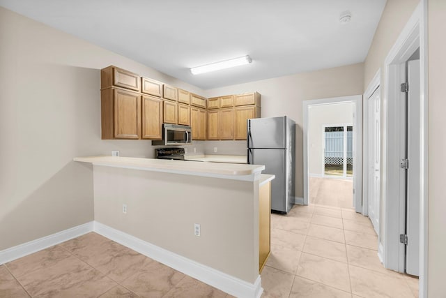 kitchen featuring kitchen peninsula, stainless steel appliances, and light tile patterned flooring