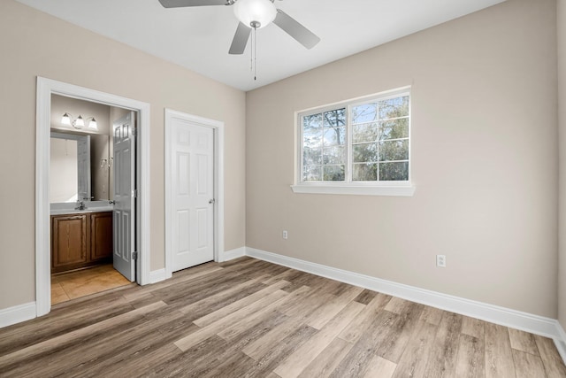 unfurnished bedroom with ensuite bathroom, ceiling fan, light hardwood / wood-style floors, and sink