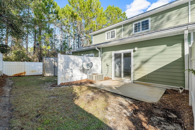 back of property with central AC, a yard, and a patio