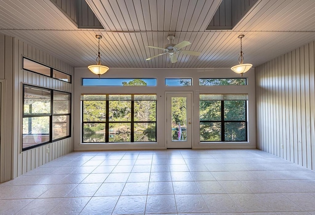 empty room with ceiling fan, wooden walls, and wooden ceiling