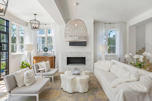 living room featuring a high end fireplace and a chandelier