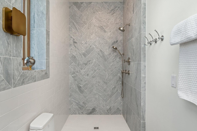 bathroom featuring tiled shower and toilet