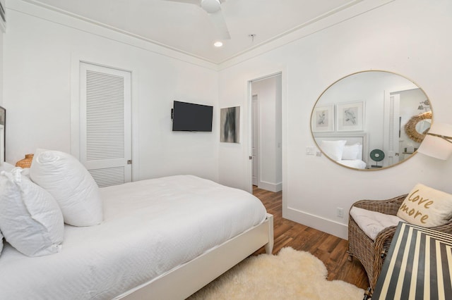 bedroom with ceiling fan, crown molding, and wood-type flooring