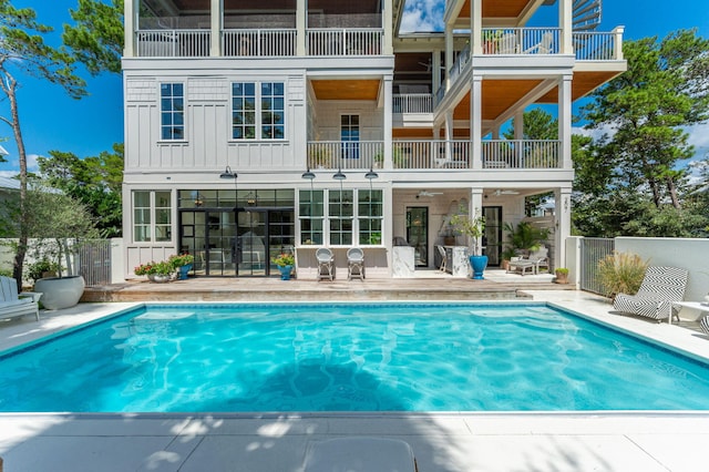 back of house with a balcony, a patio area, and a fenced in pool