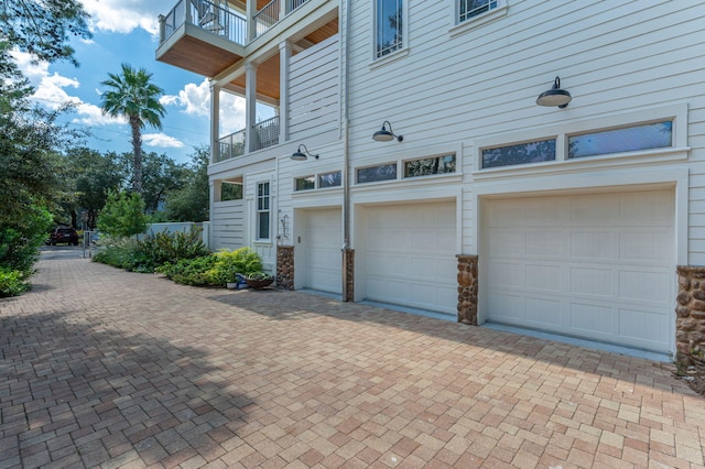 view of side of property featuring a balcony and a garage