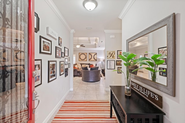 corridor with crown molding, a tray ceiling, and light tile patterned floors