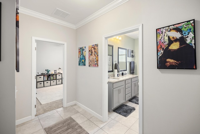 corridor featuring light tile patterned floors, ornamental molding, and sink