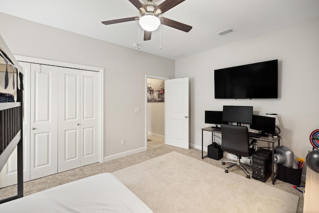 bedroom featuring ceiling fan, light carpet, and a closet